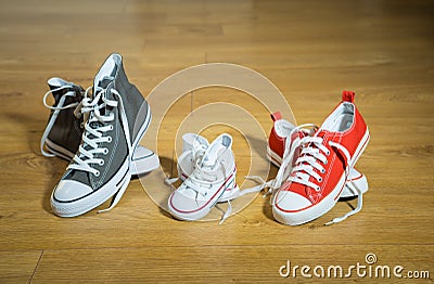 Sneakers canvas shoes of parents and child on wood floor at home in expecting a baby happy family Stock Photo