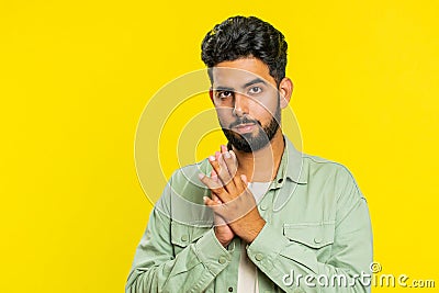 Sneaky cunning Indian young man thinking over devious villain idea, cheats, jokes, pranks, evil plan Stock Photo