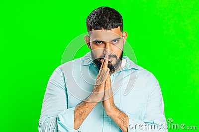 Sneaky cunning Indian young man thinking over devious villain idea, cheats, jokes, pranks, evil plan Stock Photo