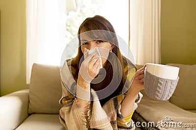 Sneezing and blowing her nose, a young woman struggles with a he Stock Photo