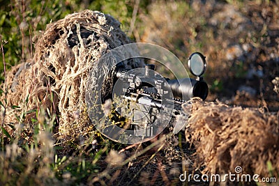 Sniper in ghillie suit with precision rifle with optic sight Stock Photo