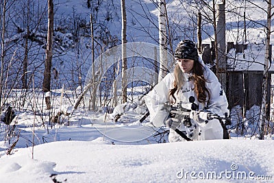 Sniper girl in white camouflage at winter forest. Stock Photo