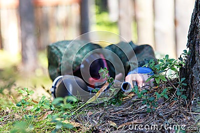Sniper with paintball gun disguised in grass. Focus on top of ba Stock Photo