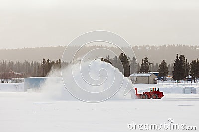 Snow blower clearing road in winter storm blizzard Stock Photo