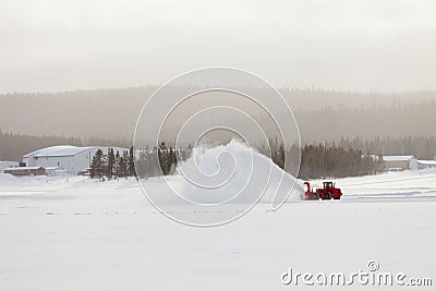 Snow blower clearing road in winter storm blizzard Stock Photo