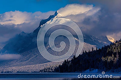 Snow Blowing Off The Rugged Mountain Stock Photo