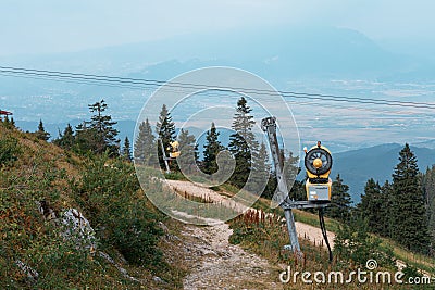 Snow cannons on the edge of a canyon with a valley in the background Editorial Stock Photo