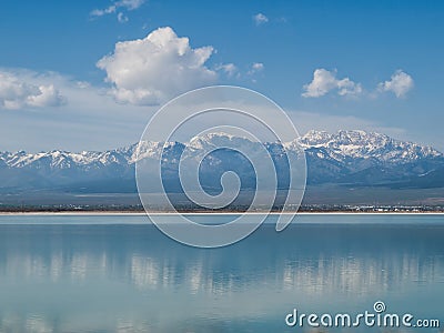 Snow capped mountains reflected in blue lake Stock Photo