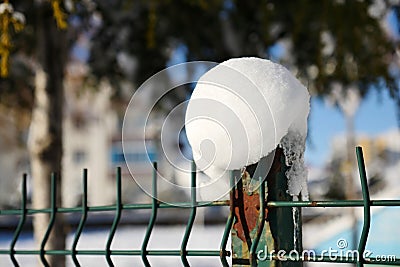 Snow cluster accumulating on the garden iron fence Stock Photo