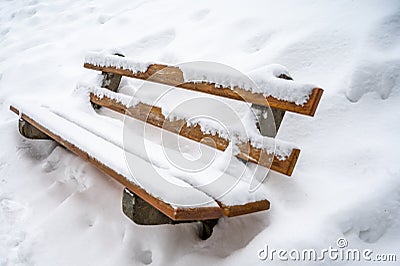 Snow covered bench. Deep snow in winter. Tranquil scene. Les Pleiades, Switzerland Stock Photo