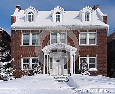 Snow covered brick house Stock Photo