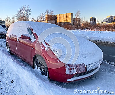 Snow covered car parked on the street. The car skidded into a snowdrift. Stock Photo