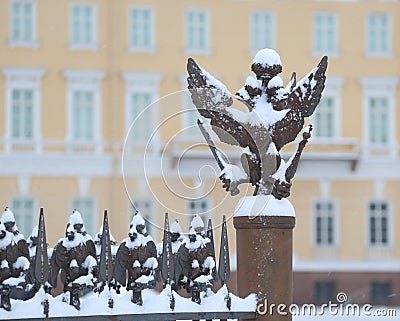 Snow-covered doubleheaded eagle on a decorative fence Stock Photo