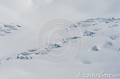 Snow covered glacier crevasses and seracs in snow field Stock Photo