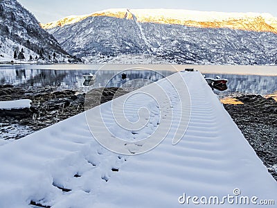 Snow-covered jetty winter landscape at the fjord lake Norway Stock Photo