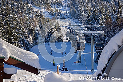 Snow covered mountains panorama - snowboarders and skiers ride on slopes and ski lifts. Ski resort in Whistler, Canada Editorial Stock Photo