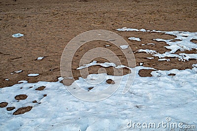 Snow covered sand. melting snow on the frost ground Stock Photo