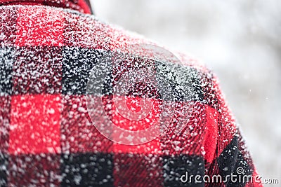 Snow covered shoulders of man in red plaid Stock Photo