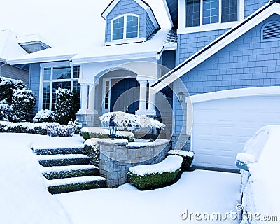 Snow covered sidewalk in front of home during winter snowfall Stock Photo