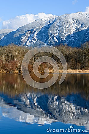 Snow covered Washington Cascade mountains reflecting in lake Stock Photo