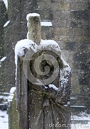 Snow falling an a graveyard staue of a mourning woman Stock Photo