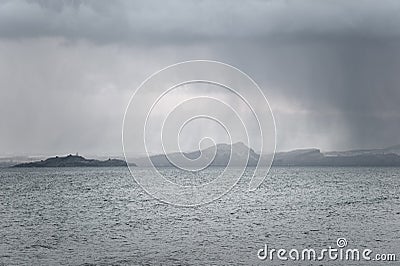 Snow falling over Arthur's Seat and Inchkeith Stock Photo