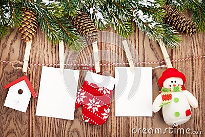 Snow fir tree, photo frames and christmas decor on rope over rustic wooden board Stock Photo