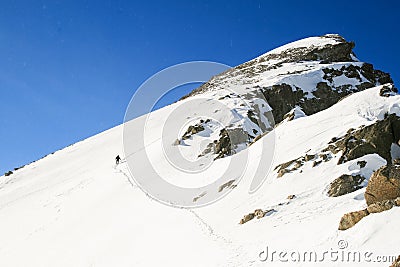 Snow hiker leaving a trail of footprints in the snow in a sunny day Stock Photo