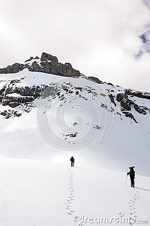 Snow hiker walking in a snowy hillside in a cloudy day Editorial Stock Photo