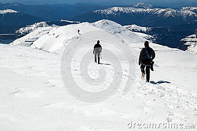 Snow hiker walking in a snowy hillside in a sunny day Stock Photo