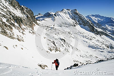 Snow hiker walking on snow with the view of the mountains and blue sky in the background Editorial Stock Photo