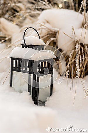 Snow on the lantern in the grass garden. Stock Photo
