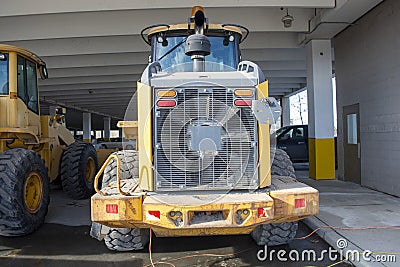 Snow Mover Wheel Loader Machine Parked in Parkade Stock Photo
