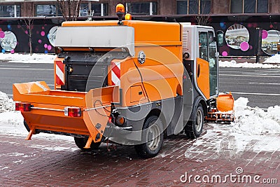 Snow plough cleaning pavements and streets which are covered in snow and mud during heavy snowfallÑŽ Stock Photo
