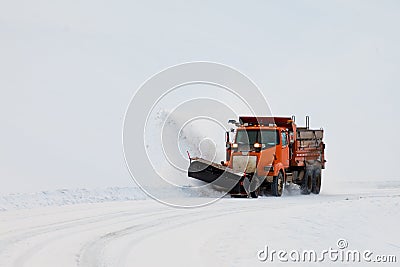 Snow plough clearing road in winter storm blizzard Stock Photo