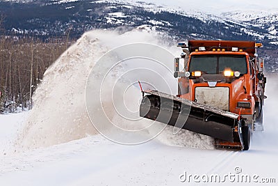 Snow plough clearing road in winter storm blizzard Stock Photo