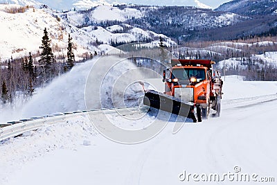 Snow plough clearing road in winter storm blizzard Stock Photo