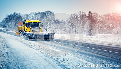 Snow plow truck clearing snowy road after snowstorm Stock Photo