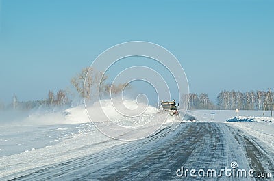 Snow removal equipment, truck, winter clears snow from the icy country road Stock Photo