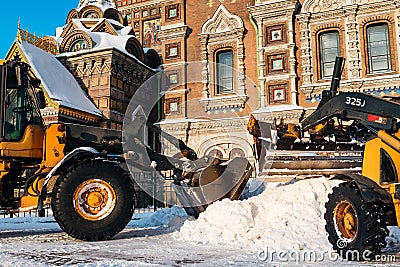 Snow removal vehicle removing snow. Tractor clears the way after heavy snowfall in St. Petersburg, Russia Editorial Stock Photo