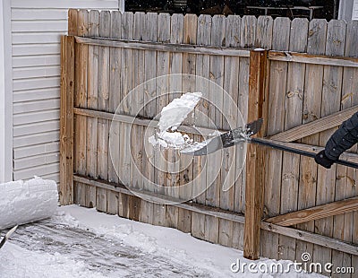 Snow shovel is throwing a scoop of snow that has been shoveled from your sidewalk Stock Photo