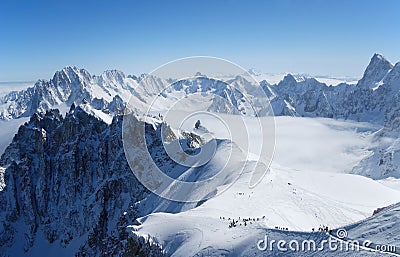 Snow slope with mountain-skiers, the Alps Stock Photo