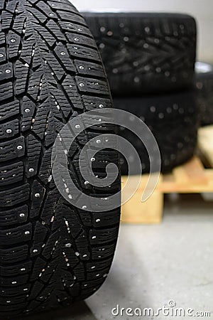 Snow tires with metal studs in garage Stock Photo