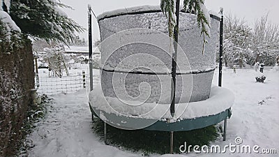 Snow on a trampoline in the back garden Stock Photo