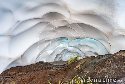 The snow tunnel Lesser Valley of Geysers in June, Kamchatka Peninsula, Russia Stock Photo