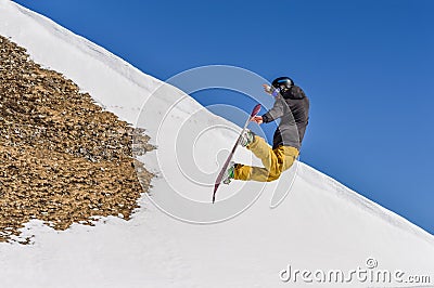 Snowboarder enjoying runs and jumps on spring`s last snow. Editorial Stock Photo