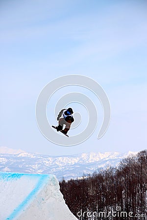 Snowboarder going off a big jump in hanazono park Stock Photo