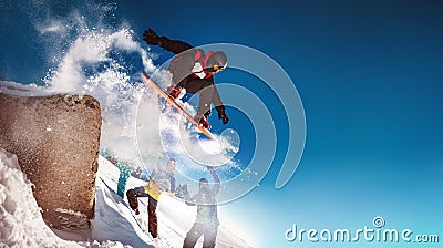 Snowboarder jumps from big rock against Stock Photo