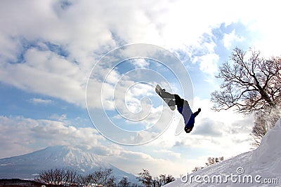 Snowboarder mid backflip at hanazono backcountry jump Stock Photo