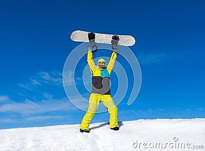 Snowboarder raised hands arms up hold snowboard on Stock Photo